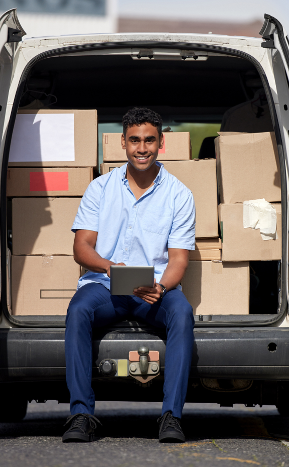 delivery guy sitting smiling with van